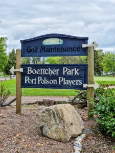 Directional sign at Boettcher Park under a cloudy sky in Polson, Montana