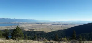 View from above Polson where the Flathead River exits Flathead Lake, U.S. Highway 93 and the Mission Mountain Range visible